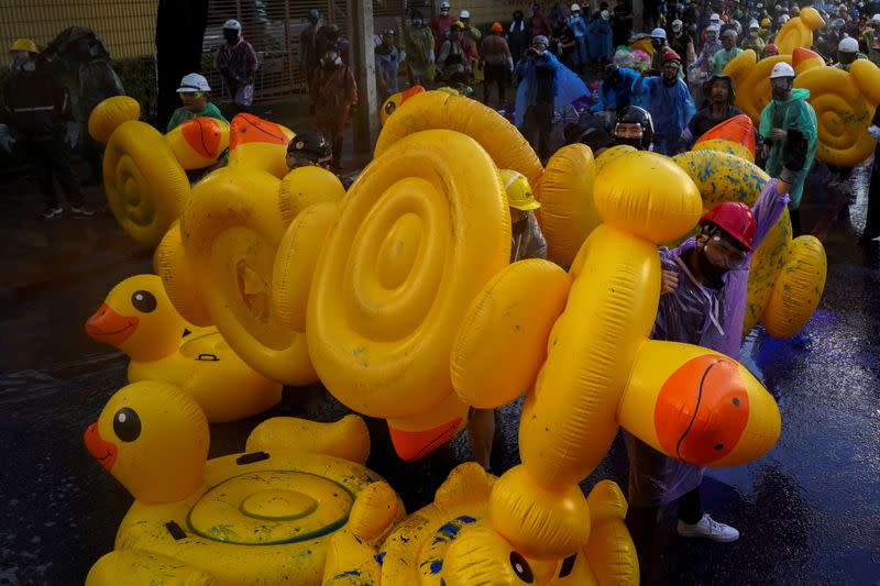 Demonstrators use inflatable rubber ducks as shields to protect themselves from water cannons during an anti-government protest in Bangkok