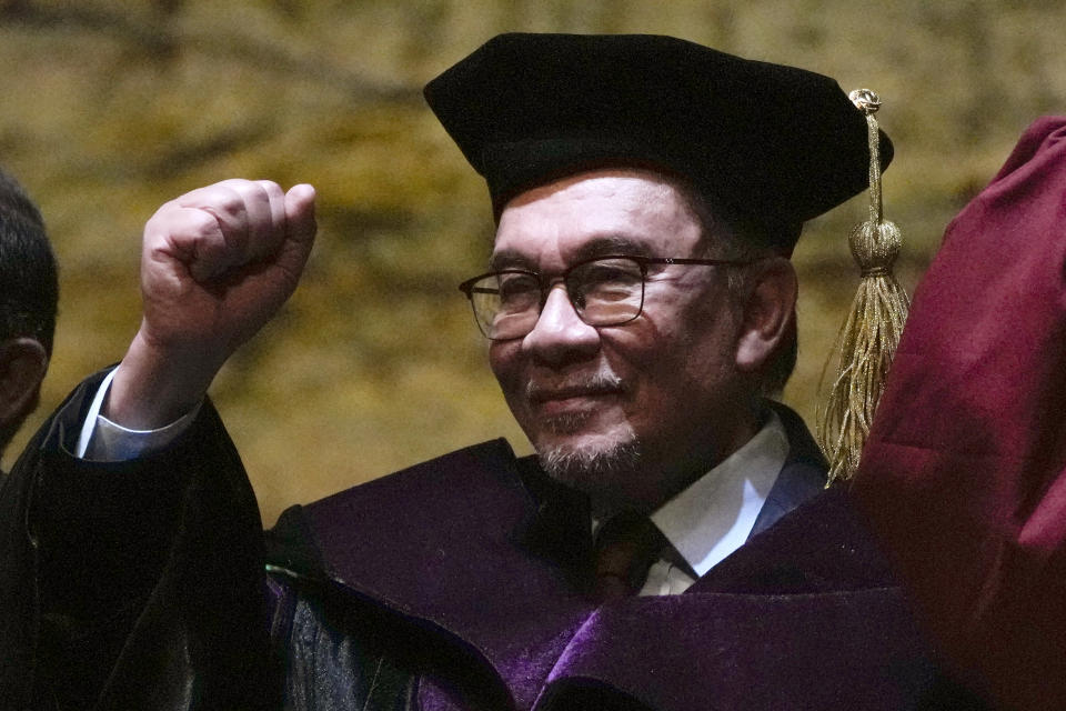 Malaysia's Prime Minister Anwar Ibrahim raises his clenched fist during the singing of the school hymm after he is conferred a Doctor of Laws degree, honoris causa at the University of the Philippines in Quezon city, Philippines on Thursday March 2, 2023. (AP Photo/Aaron Favila)
