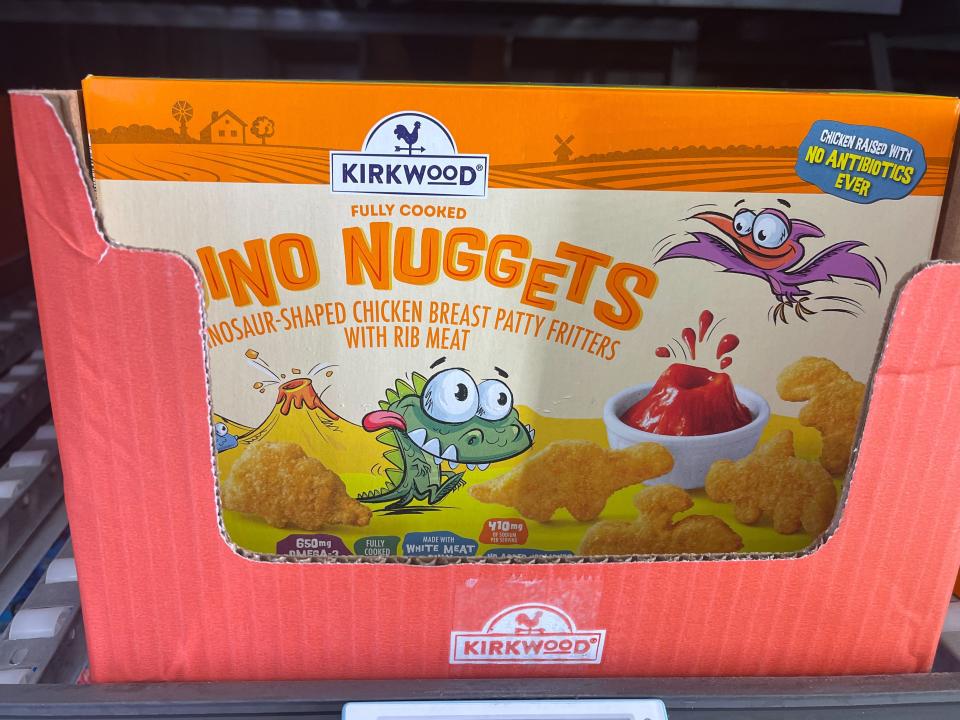 Box with "Dino Nuggets" text and illustration of a dinosaur inside of a cardboard box on a shelf