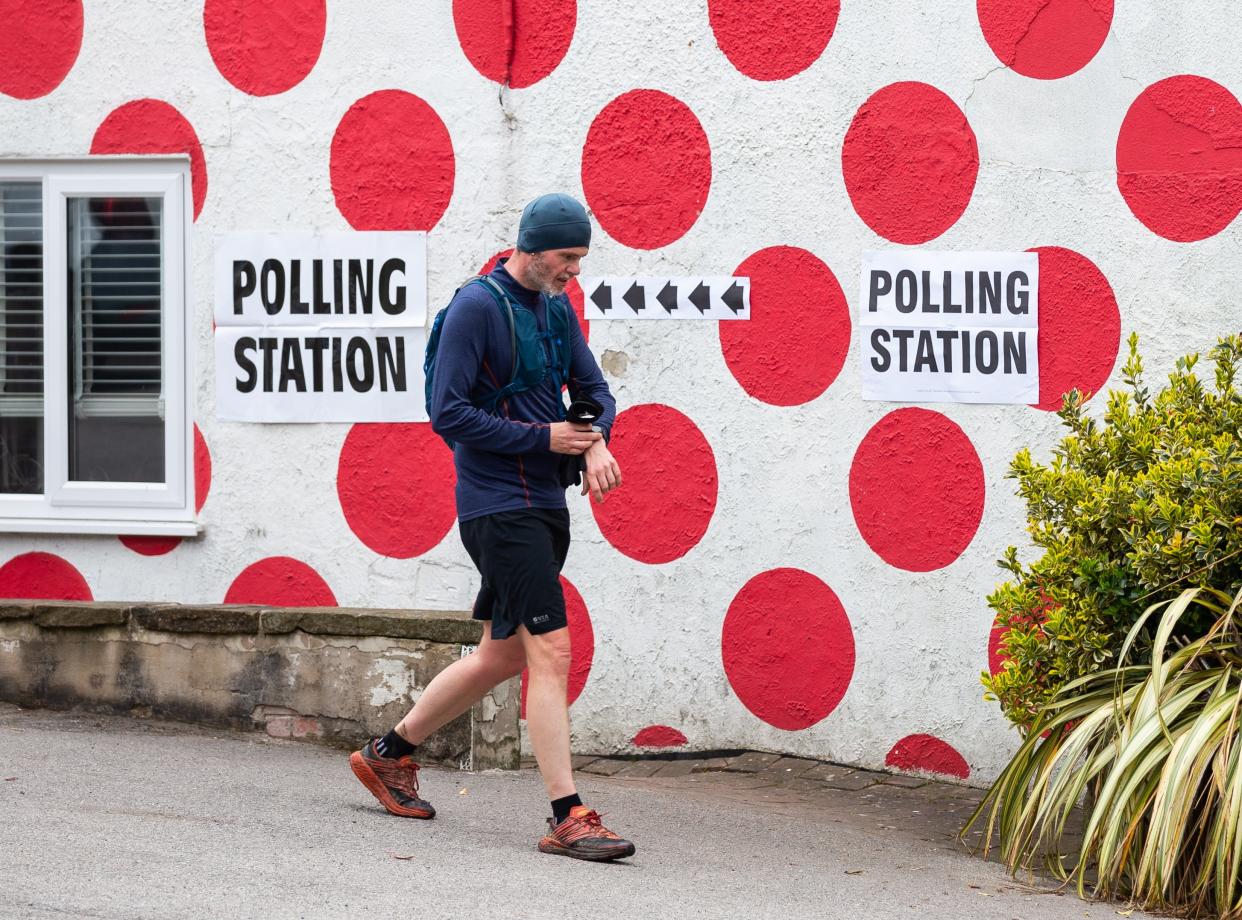 A person walks past a polling station at Langsett Barn in Sheffield, Britain (EPA)