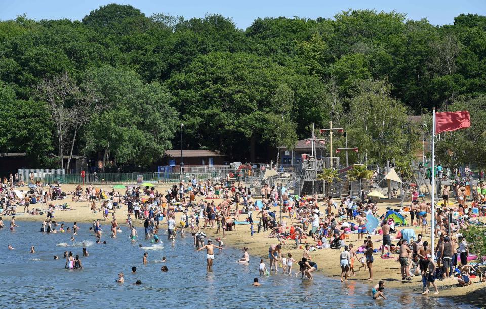 People enjoy the sunshine in the water and on the beach at Ruislip Lido in west London on May 30, 2020, as lockdown measures are eased during the novel coronavirus COVID-19 pandemic. - Britain's Prime Minister Boris Johnson has set out a gradual easing of lockdown measures in England, with socially distanced groups of six friends and families allowed to meet in parks and gardens from June 1. (Photo by JUSTIN TALLIS / AFP) (Photo by JUSTIN TALLIS/AFP via Getty Images)