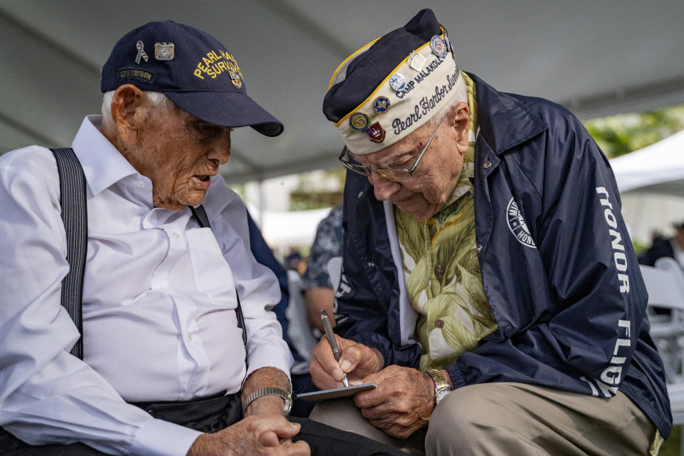 Pearl Harbor survivors Harry Chandler, 102, left, and Herb Elfring, 101, talk to each other during the 82nd Pearl Harbor Remembrance Day ceremony on Thursday, Dec. 7, 2023, at Pearl Harbor in Honolulu, Hawaii. Pearl Harbor Survivors, World War II veterans and their families gather in Pearl Harbor to commemorate those who perished 82 years ago. (AP Photo/Mengshin Lin)
