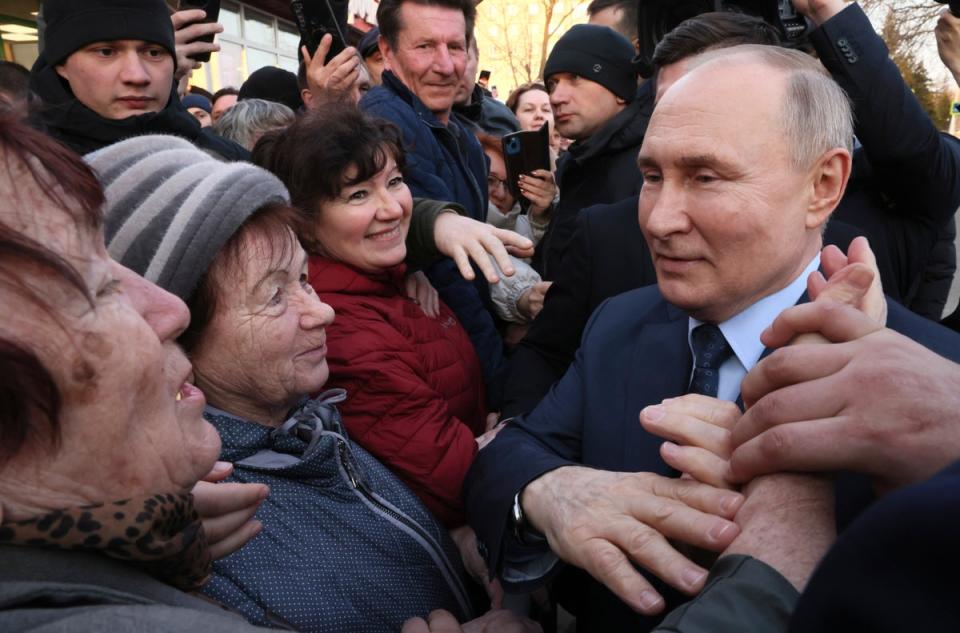 Russian president Vladimir Putin meets with residents following a visit to a greenhouse complex near Moscow ahead of elections this weekend (AP)