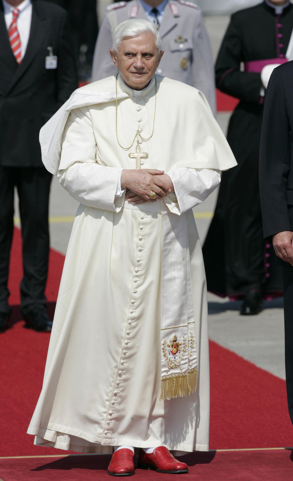 FILE - Pope Benedict XVI listens to the German national anthem after his arrival at an airport near Cologne, western Germany, on Aug. 18, 2005. When Cardinal Joseph Ratzinger became Pope Benedict XVI and was thrust into the footsteps of his beloved and charismatic predecessor, he said he felt a guillotine had come down on him. The Vatican announced Saturday Dec. 31, 2022 that Benedict, the former Joseph Ratzinger, had died at age 95. (AP Photo/ Thomas Kienzle, File)