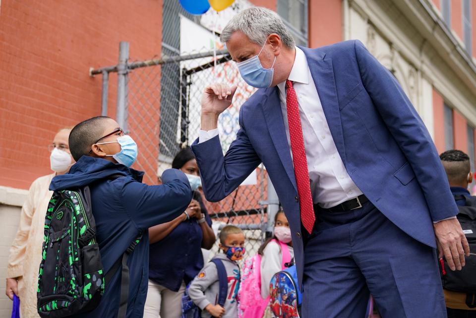 New York Mayor Bill de Blasio, right, greets students as they arrive for in-person classes outside Public School 188 The Island School, Tuesday, Sept. 29, 2020, in the Manhattan borough of New York.