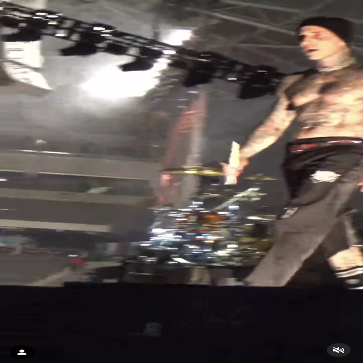travis leaves his drum set to walk on the stage
