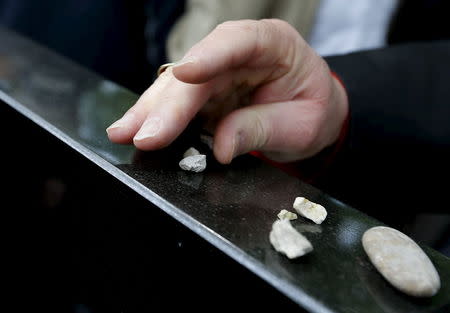 A man puts stones top of a tomb during the funeral of the remains of Holocaust victims in the Jewish cemetery in Budapest, Hungary April 15, 2016. REUTERS/Laszlo Balogh