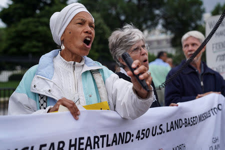 Activist Lucy Murphy sings during a vigil outside the White House to celebrate the joint summit between U.S. President Donald Trump and North Korean leader Kim Jong Un held in Singapore, in Washington, U.S., June 11, 2018. REUTERS/Toya Sarno Jordan