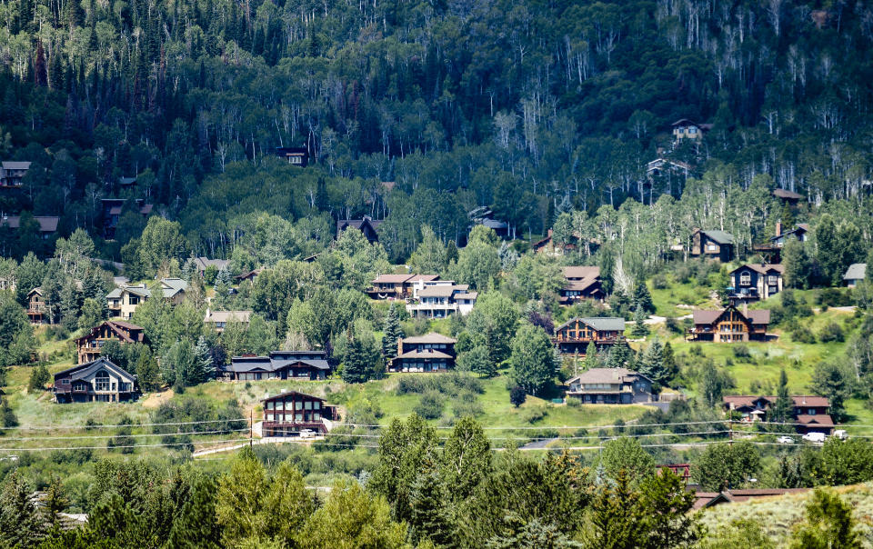 Houses dot a hillside in Steamboat Springs, Colo., Wednesday, Aug. 3, 2022, in Steamboat Springs. The city council passed a rule in June that could prove to be a model for other vacation towns: A ban on new short-term rentals in most of the city and a ballot measure to tax bookings at 9% to fund affordable housing. (AP Photo/Thomas Peipert)