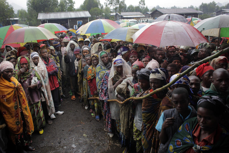 In this Aug. 8, 2012, file photo, internally displaced Congolese men and women wait for a World Food Program energy biscuits to be distributed in Kibati, north of Goma, eastern Congo. The World Food Program chief warned Thursday, Sept. 17, 2020, that millions of people are closer to starvation because of the deadly combination of conflict, climate change and the COVID-19 pandemic and he urged donor nations and billionaires to help feed them and ensure their survival. (AP Photo/Jerome Delay, File)