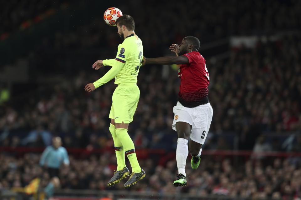 Barcelona's Gerard Pique, left, and Manchester United's Romelu Lukaku jump for the ball during the Champions League quarterfinal, first leg, soccer match between Manchester United and FC Barcelona at Old Trafford stadium in Manchester, England, Wednesday, April 10, 2019. (AP Photo/Jon Super)