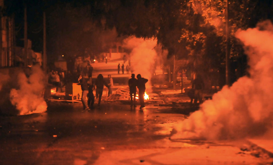 <p>Tear gas smoke billows as Tunisian protestors throw stones towards security forces in Tunis’ Djebel Lahmer district early on Jan. 10, 2018 after price hikes ignited protests in the North African country. (Photo: Sofiene Hamdaoui/AFP/Getty Images) </p>