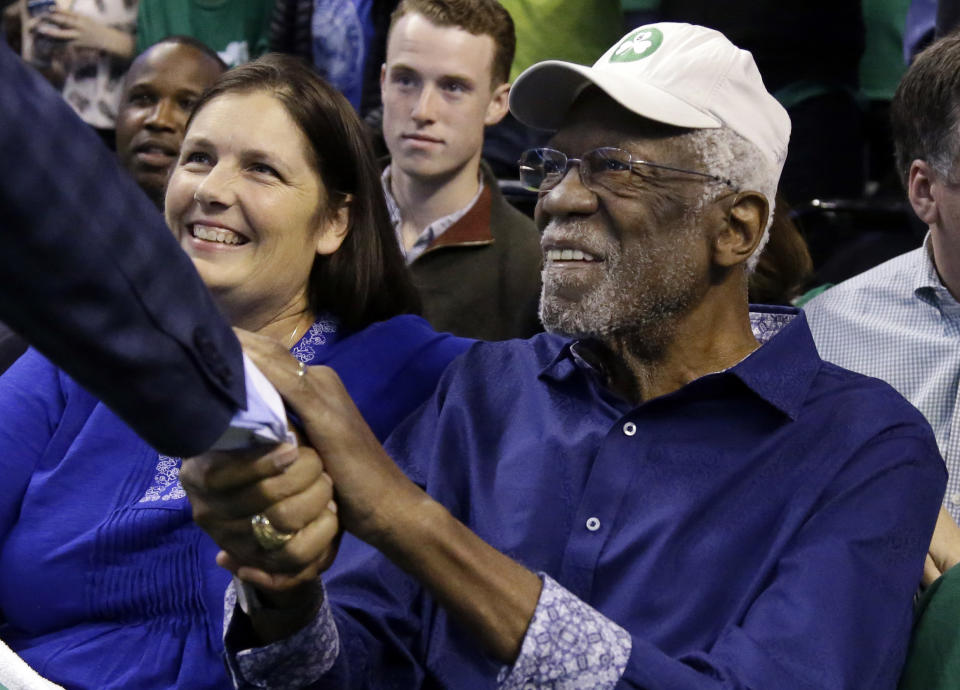 FILE - Boston Celtics legendary player Bill Russell is greeted at his seat before Game 1 of an NBA basketball second-round playoff series between the Boston Celtics and the Philadelphia 76ers, Monday, April 30, 2018, in Boston. Basketball fans hoping to buy something from Bill Russell’s memorabilia collection should expect some big-name competition. Hall of Famers Shaquille O’Neal and Charles Barkley say they're interested in bidding on items that Russell — a civil rights icon and the most decorated champion in team sports history — is selling off. An online auction with 429 lots began last week and will culminate in a live event at the TD Garden on Friday, Dec. 10, 2021 (AP Photo/Elise Amendola, File)