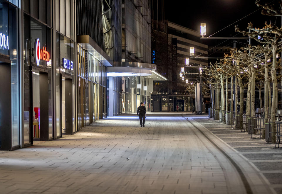 A man walks through the empty shopping street in Frankfurt, Germany, Friday, Feb. 12, 2021. Germany authorities extended the country's partial lockdown for another four weeks to battle the coronavirus pandemic. (AP Photo/Michael Probst)