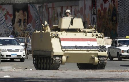 A soldier stands guard in a tank in Tahrir square in Cairo August 14, 2014. REUTERS/Mohamed Abd El Ghany