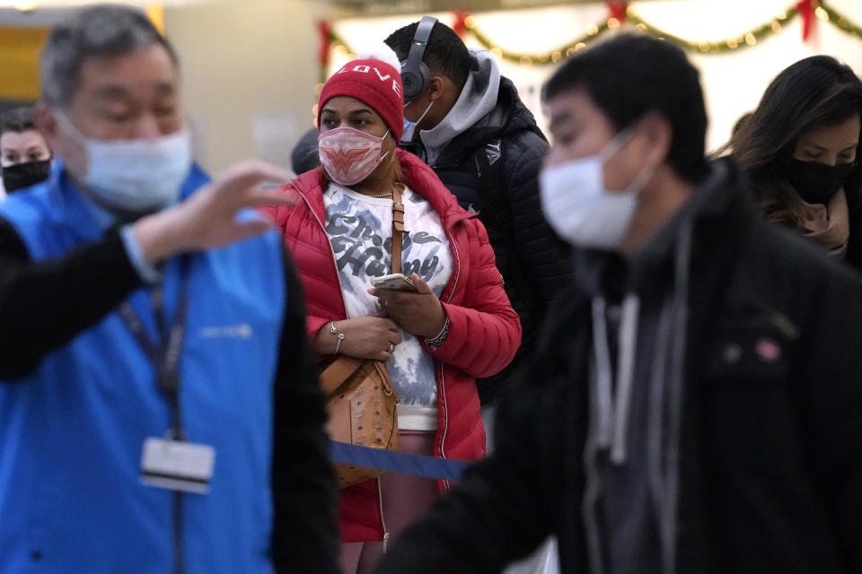 Travelers line up for flights at O'Hare International Airport in Chicago, Thursday, Dec. 30, 2021. (AP Photo/Nam Y. Huh)