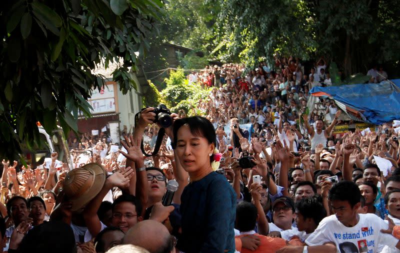 FILE PHOTO: Aung San Suu Kyi stands among supporters gathered to hear her speech outside the headquarters of her National League for Democracy party in Yangon