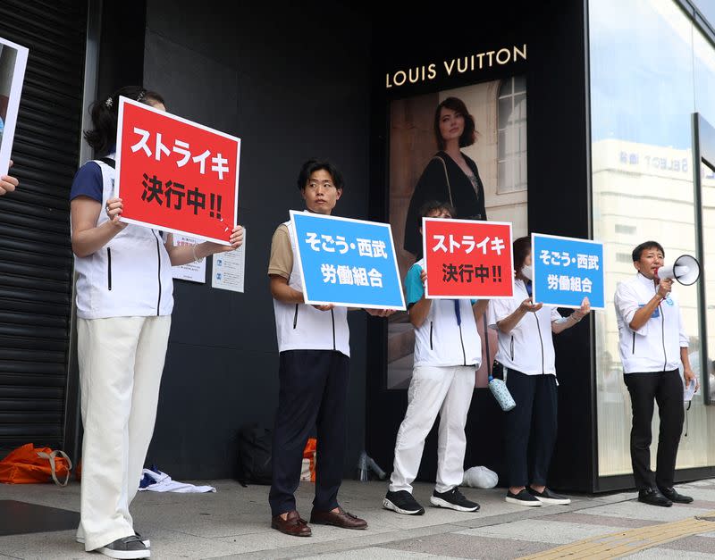 Union workers of Sogo & Seibu hold banners which read 'on strike' in front of the company's flagship Seibu Ikebukuro store in Tokyo