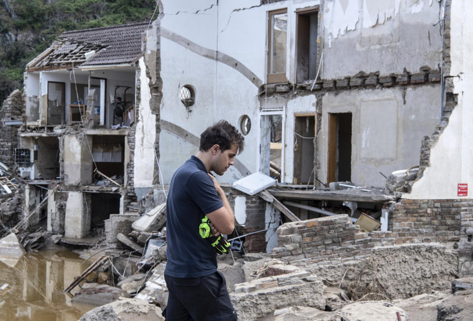 A fireman walks in front of completely destroyed houses in the village of Mayschoß, Germany, Tuesday, July 20, 2021. Numerous houses in the village were badly affected or completely swept away by the flood wave.( Boris Roessler/dpa via AP)