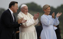 Pope Francis applauds children between Panamanian President Juan Carlos Varela and first lady Lorena Castillo de Varela after landing at Tocumen international airport in Panama City, Wednesday, Jan. 23, 2019. Pope Francis will be in Panama Jan. 23-27 for World Youth Day events. (AP Photo/Alessandra Tarantino)