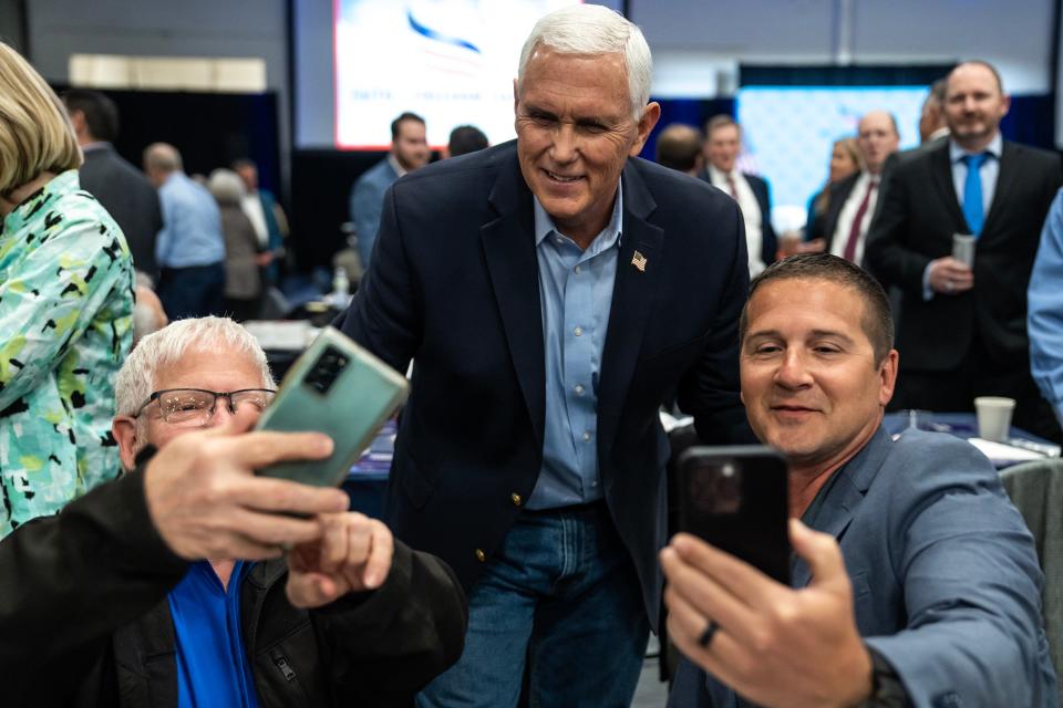 Former Vice President Mike Pence poses for a selfie with Ron and Jason Patterson before the start of the Iowa Faith & Freedom Coalition's annual spring kickoff event, on Saturday, April 22, 2023, in Clive, Iowa.