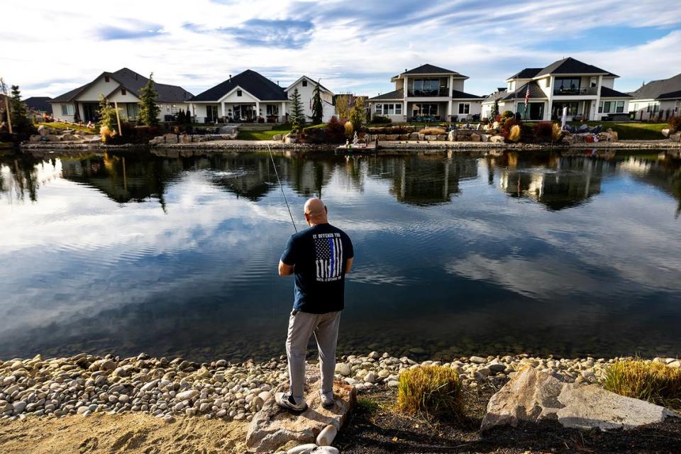 A retired 30-year veteran of the Los Angeles County Sheriff’s Department fishes behind his new home on a man-made pond at the Legacy planned community in Eagle, Idaho. Many of his neighbors are retired California police officers and firefighters.