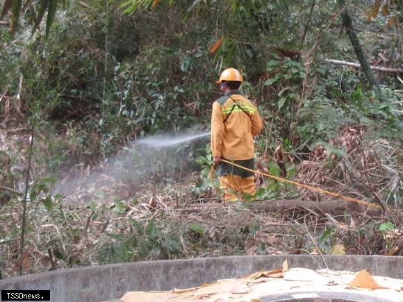 林業保育署南投分署森林護管員在林班與墳墓區間噴阻燃劑。（圖：林業保育署南投分署提供）