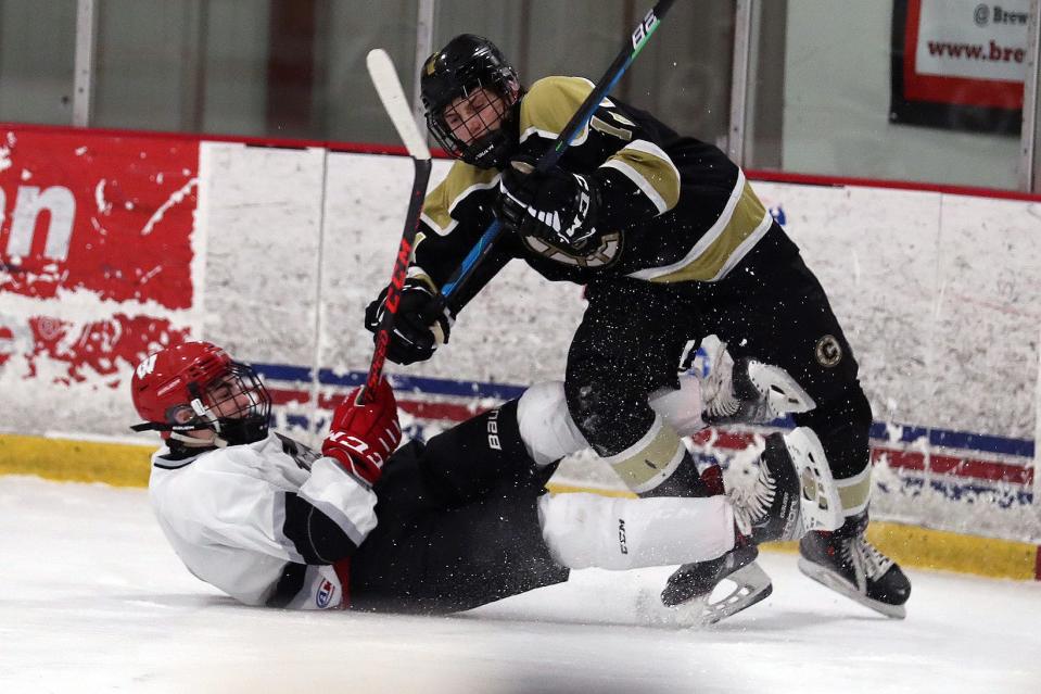 From right, Clarkstown's Chase Chalfin (14) and the BYSNS's Sava Makarenko (10) get tangled up while going after the puck during hockey action at the Brewster Ice Arena Jan. 15, 2022.