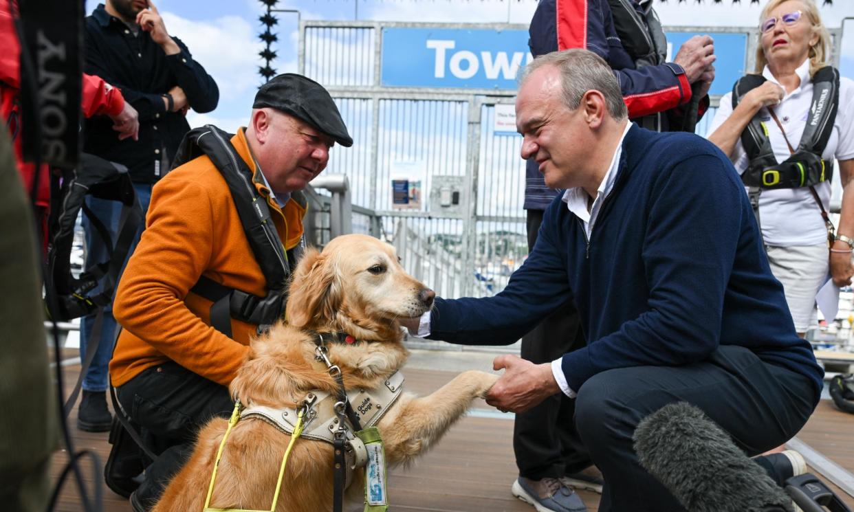 <span>Steve Darling and his guide dog, Jennie, with the Lib Dem leader, Ed Davey, at Torquay harbour on 11 June.</span><span>Photograph: Finnbarr Webster/Getty Images</span>