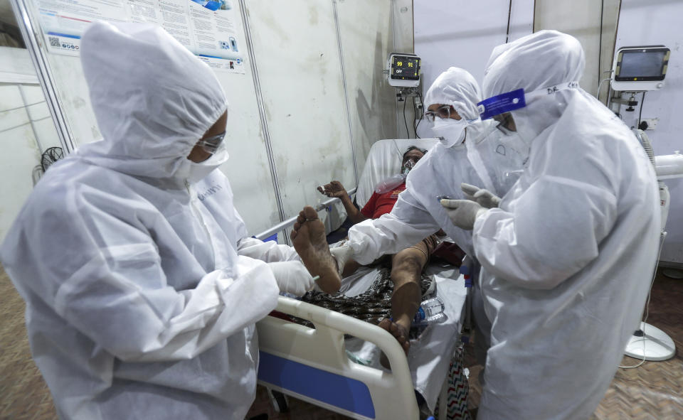Doctors check touch sensitivity response of a patient at the BKC jumbo field hospital, one of the largest COVID-19 facilities in Mumbai, India, Thursday, May 6, 2021. (AP Photo/Rafiq Maqbool)