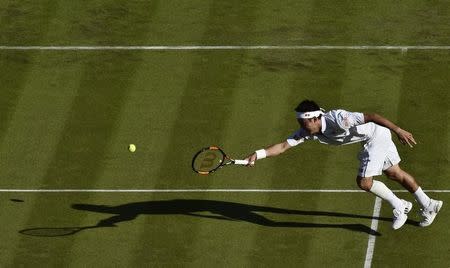 Kei Nishikori of Japan stretches for a shot during his match against Simone Bolelli of Italy at the Wimbledon Tennis Championships in London, June 29, 2015. REUTERS/Toby Melville