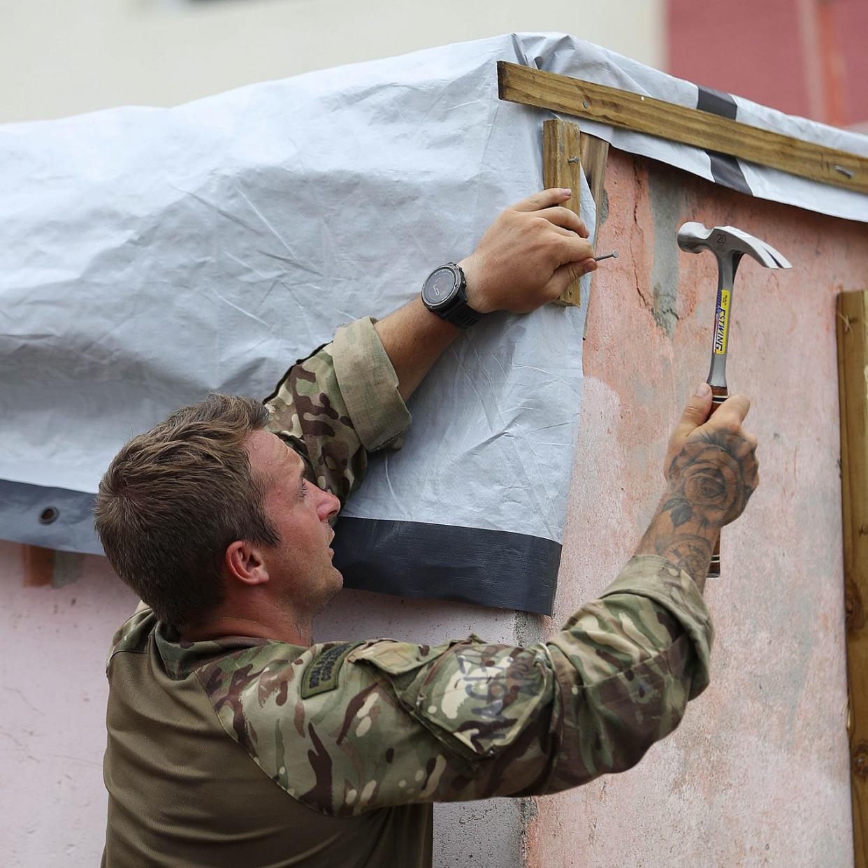 Marine Jordan Harding of 40 Commando Royal Marines helping to fix up Alvin and Dorothy Nibbs' house in Road Town, Tortola (Ministry of Defence/PA)