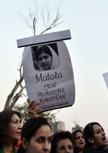 A Pakistani activist carries a placard with a photograph of gunshot victim Malala Yousafzai as they shout ant-Taliban slogans during a protest rally in Islamabad. International outrage grew Thursday at the shooting of a teenage Pakistani campaigner by the Taliban, with US President Barack Obama leading condemnation of the "disgusting" attack