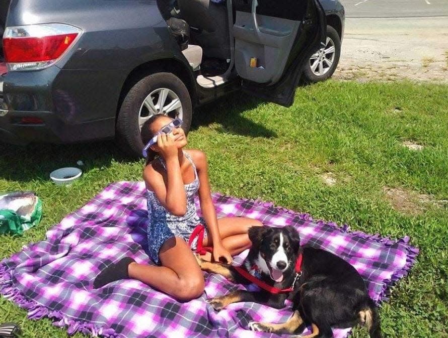 Serabi Francis watches the Aug. 21, 2017, total solar eclipse with the family dog, Sozin, by her side. The family traveled from East Stroudsburg, Pennsylvania, to Hopkinsville, Kentucky to catch totality.