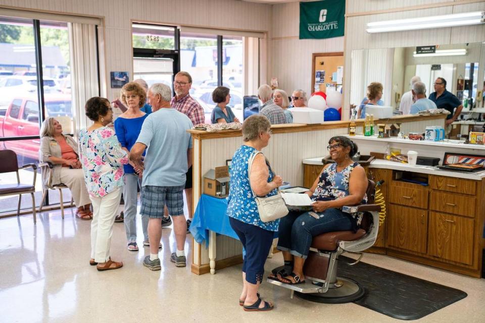 People line up inside Gary’s Barber Shop in the Derita area to celebrate Gary Carter’s 59 years of cutting hair for the community. Many came by to chat and get a picture with Gary before the shop closes in late July.