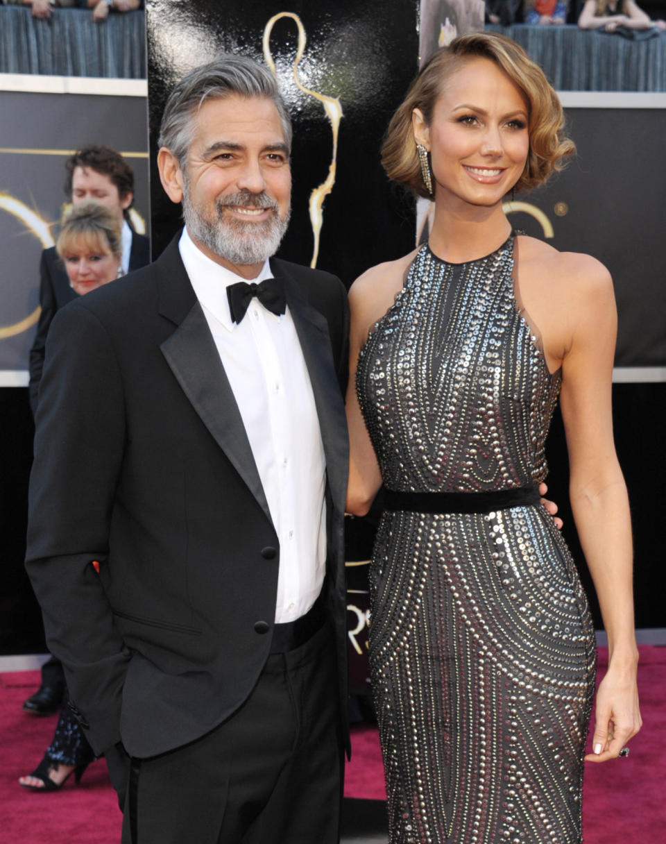 FILE - In this Feb. 24, 2013 file photo, actor George Clooney, left, and Stacy Keibler arrive at the Oscars at the Dolby Theatre in Los Angeles. Clooney, 52, Hollywood’s most determined bachelor famous for a litany of fleeting loves, including Keibler, has taken himself off the romantic market and proposed to 36-year-old attorney, Amal Alamuddin. A spokesman for the Oscar-winning actor and producer did not respond to requests for comment Monday, April 28, 2014. (Photo by John Shearer/Invision/AP, file)