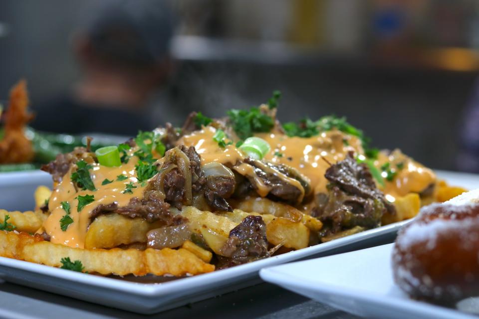 Ready to indulge? Then dig into Lantern Local Tavern's loaded fries shown here topped with shaved steak, sauteed onions & peppers and beer cheese.