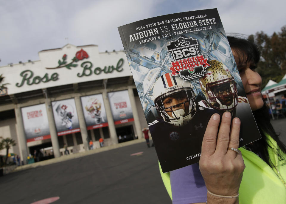 FILE - In this Jan. 6, 2014, file photo, a vendor sells a program outside the Rose Bowl before the BCS National Championship NCAA college football game between Auburn and Florida State in Pasadena, Calif. The Rose Bowl was denied a special exemption from the state of California to allow a few hundred fans to attend the College Football Playoff semifinal on Jan. 1, putting the game staying in Pasadena in serious doubt. A person involved with organizing the game told The Associated Press the Tournament of Roses' request was denied earlier this week. (AP Photo/Chris Carlson, File)