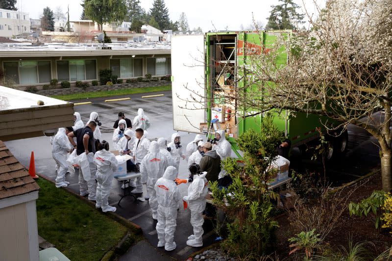 Members of a Servpro cleanup crew wear hazardous material suits as they prepare to enter Life Care Center of Kirkland, the Seattle-area nursing home at the epicenter of one of the biggest coronavirus outbreaks in the United States, in Kirkland