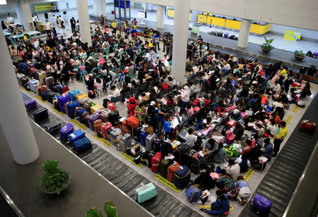 Overseas Filipino Workers (OFW) from Kuwait gather upon arrival at the Ninoy Aquino International Airport in Pasay city, Metro Manila, Philippines February 21, 2018. Following President Rodrigo Duterte's call to evacuate workers after a Filipina was found dead stuffed inside a freezer. REUTERS/Romeo Ranoco