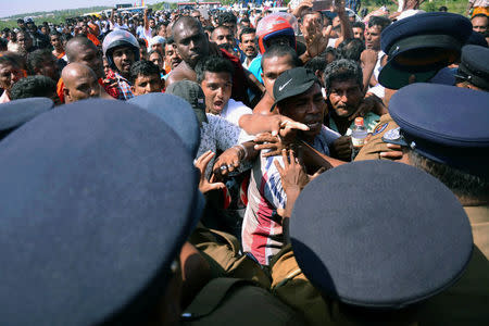 FILE PHOTO: Demonstrator shout at police officers at a protest against the launching of a $5 billion Chinese investment zone by China Merchants Port Holdings Company, in Mirijjawila, Sri Lanka January 7, 2017. REUTERS/Stringer/File Photo