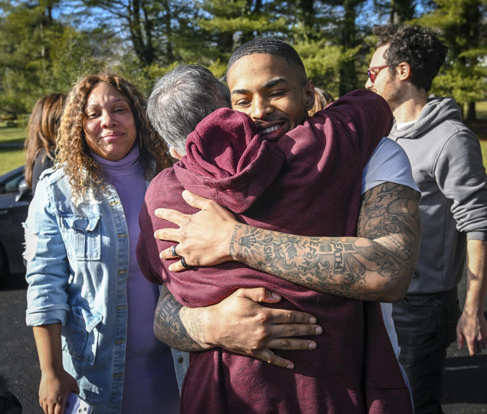 Keith Davis Jr. hugs supporter Peggy Amaker as he arrives at a gathering following his released from custody Friday, Jan. 13, 2023, in Baltimore, after prosecutors dropped all charges against him. Davis was tried for the same murder four times and was awaiting a potential fifth trial when newly elected State's Attorney Ivan Bates announced his decision to dismiss the case. (Jerry Jackson/The Baltimore Sun via AP)