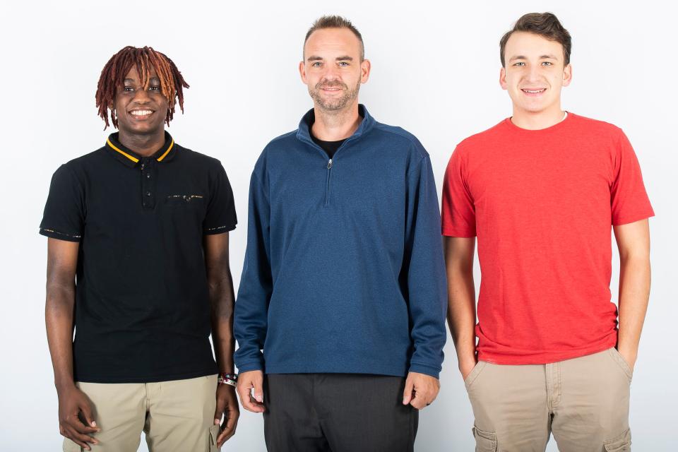 Dover basketball players Ian Ifill (left) and Bronson Link (right) pose for a photo with first-year head coach Dan Overmiller during YAIAA winter sports media days Wednesday, November 8, 2023, in York.