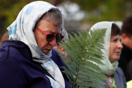 A woman holds a fern during a vigil for the victims of the mosque attacks during an ecumenical celebration in Christchurch, New Zealand, March 21, 2019. REUTERS/Jorge Silva