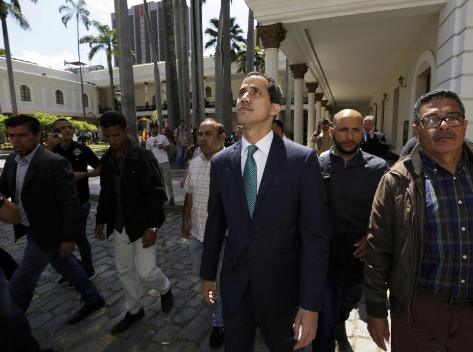 Opposition leader Juan Guaido, center, who has declared himself the interim president of Venezuela, center, is surrounded by bodyguards upon his arrival at the National Assembly in Caracas, Venezuela, Monday, Feb. 4, 2019. Germany, Spain, France, the U.K. and Sweden have announced that they are recognizing Guaido as the country's interim president and are urging him to hold a new presidential election.(AP Photo/Fernando Llano)