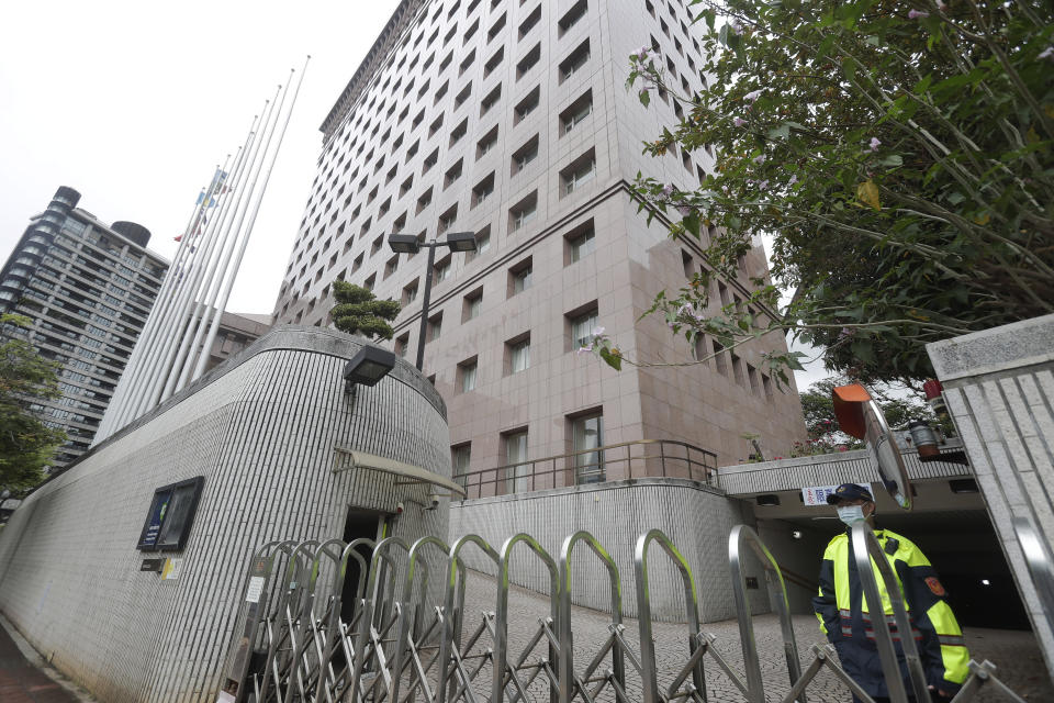 A policeman guards at the door of the Diplomatic Quarter building which houses the Honduran Embassy, in Taipei, Taiwan, Sunday, March 26, 2023. Honduras formed diplomatic ties with China on Sunday after breaking off relations with Taiwan, which is now recognized by only 13 sovereign states, including Vatican City. (AP Photo/Chiang Ying-ying)