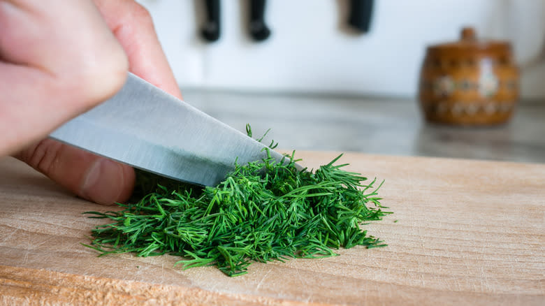 chopping fresh dill cutting board
