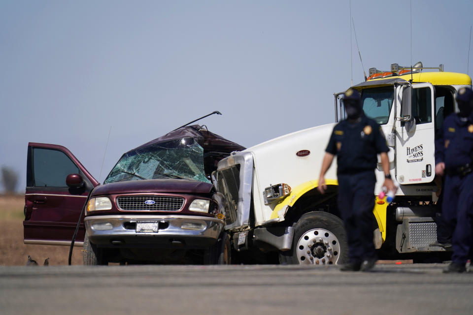 FILE - In this March 2, 2021 file photo law enforcement officers work at the scene of a deadly crash in Holtville, Calif. A Mexican man has been charged with coordinating a smuggling effort that left 13 people dead when their overloaded SUV was struck by a big-rig just over the border in California. The U.S. attorney's office says Jose Cruz Noguez of Mexicali appeared in federal court in El Centro on Tuesday, March 30, 2021, but didn't enter a plea to smuggling and conspiracy charges. (AP Photo/Gregory Bull, File)