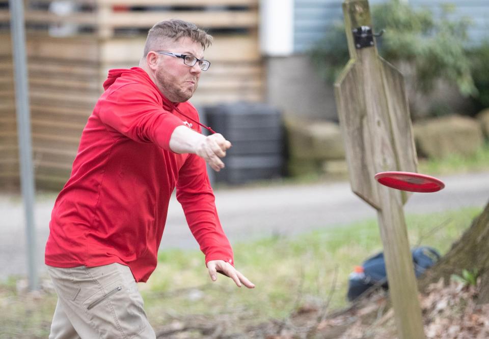 Justin Worrell of Paris throws his drive on hole No. 3 at Massillon's Oak Ledges disc golf course.