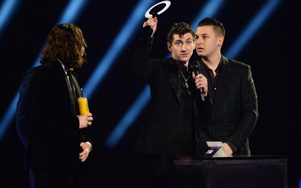 Alex Turner, Jamie Cook, Nick O'Malley, and Matt Helders of Arctic Monkeys accept their British Group Award on stage at the Brit Awards 2014